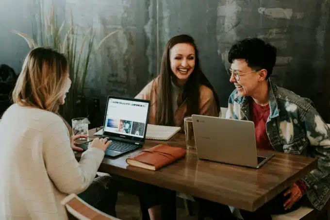 Equipo creativo colaborando en una agencia de marketing digital, riendo y compartiendo ideas.