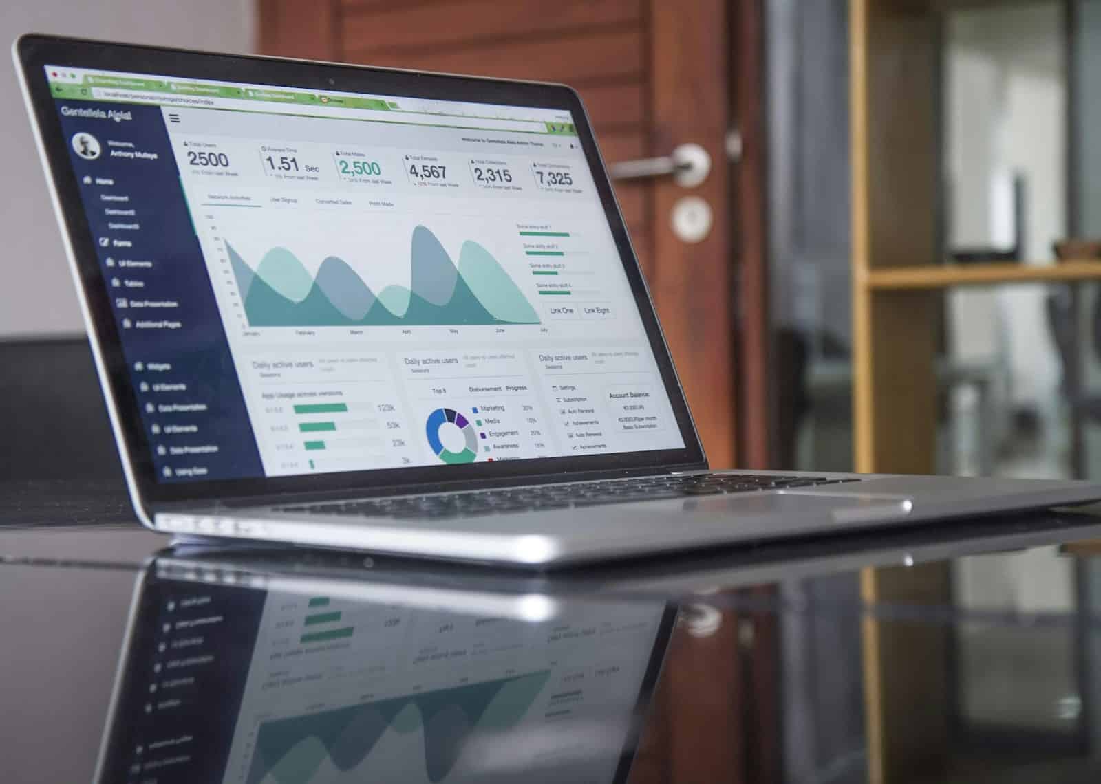 Portátil en mesa de vidrio utilizado para optimizar tu tienda online