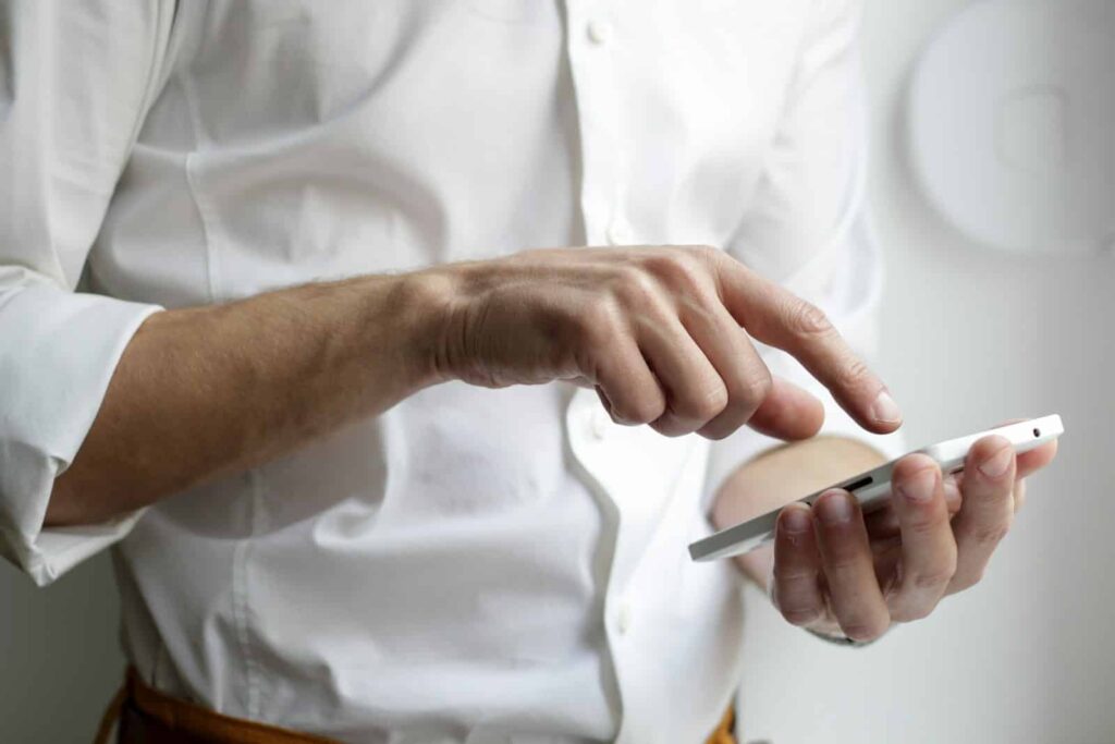 Persona usando un smartphone para buscar negocios locales posicionados por SEO local