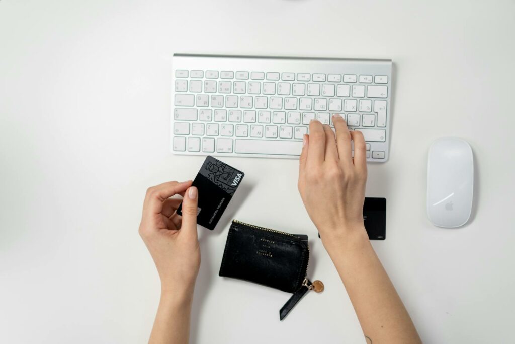 Manos utilizando un teclado y sosteniendo una tarjeta de crédito, representando estrategias de contenido para e-commerce