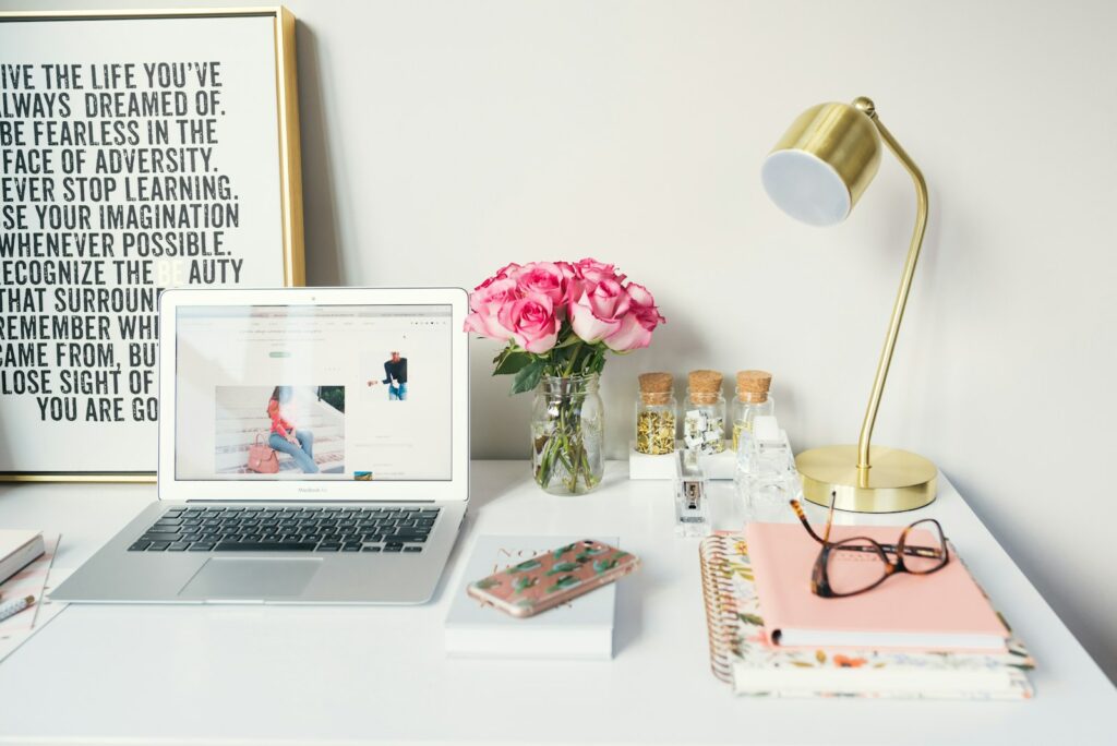Espacio de trabajo organizado con un portátil, flores y accesorios, ideal para crear una tienda online con PrestaShop.